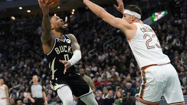 Milwaukee Bucks guard Damian Lillard (0) shoots around San Antonio Spurs center Zach Collins (23)